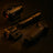 Two black rifle scopes and grips on a dark surface