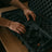 Person handling a black gel blaster in a protective case on a wooden surface